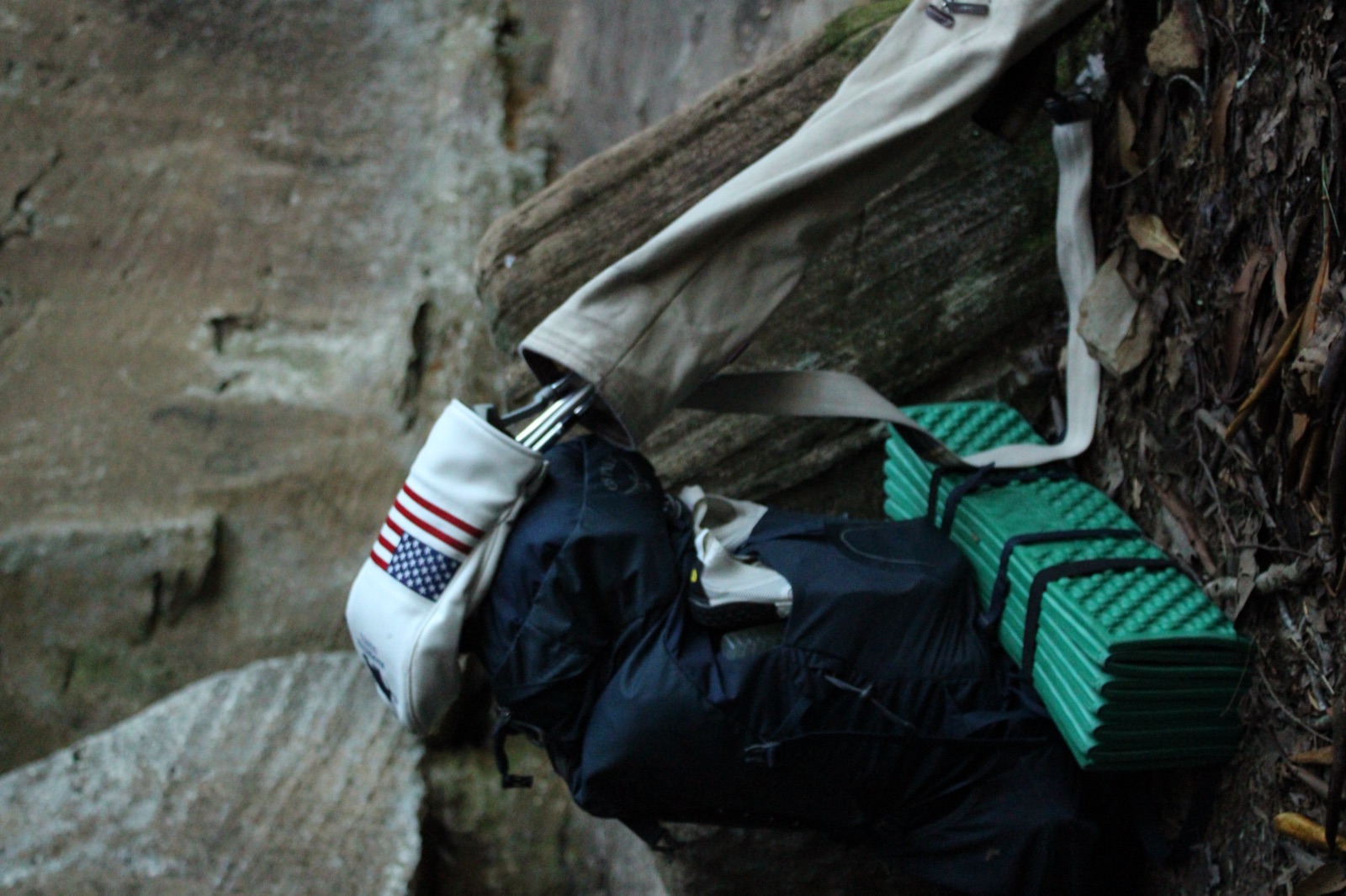 Golf bag and pack against rock wall